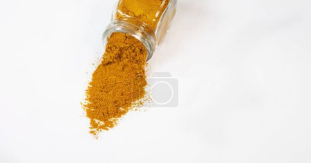 Photo for Curry Powder falling against white background - Royalty Free Image
