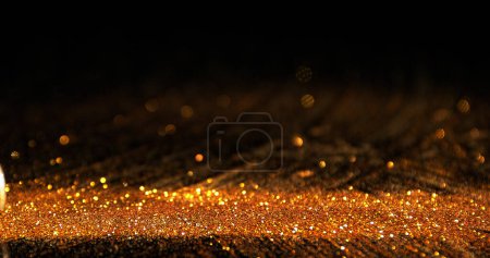 Photo for Gold Powder falling against Black Background - Royalty Free Image