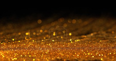 Téléchargez les photos : Poudre d'or tombant sur fond noir - en image libre de droit