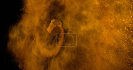 Foto de Cúrcuma, curcuma longa, Polvo en un tarro pequeño que cae sobre el fondo negro, Especia india - Imagen libre de derechos