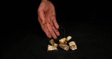 Photo for Hand and Gold Nuggets, Nugget, Falling on Black Background - Royalty Free Image