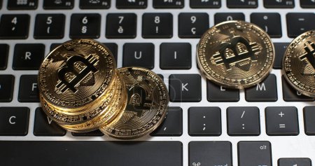 Foto de Bitcoins en el fondo del teclado del ordenador - Imagen libre de derechos