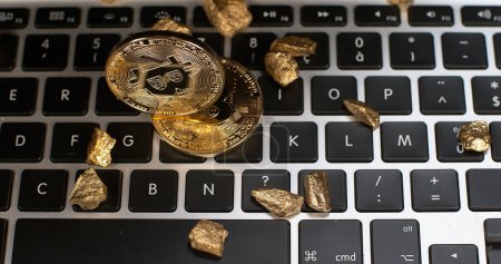 Téléchargez les photos : Bitcoins et pépites d'or sur fond de clavier d'ordinateur - en image libre de droit