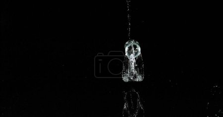 Photo for Glass of Water Bouncing and Splashing on Black Background - Royalty Free Image