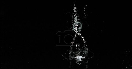 Foto de Vaso de agua rebotando y salpicando sobre fondo negro - Imagen libre de derechos