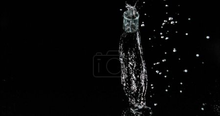 Téléchargez les photos : Verre d'eau rebondissant et éclaboussant sur fond noir - en image libre de droit