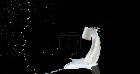 Foto de Vaso de leche rebotando y salpicando sobre fondo negro - Imagen libre de derechos