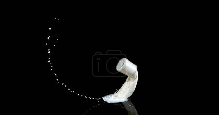Photo for Glass of Milk Bouncing and Splashing on Black Background - Royalty Free Image
