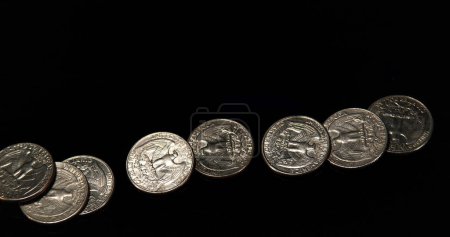 Photo for Quarter Dollar Coins Falling, Rolling and Sliding on Black Background - Royalty Free Image