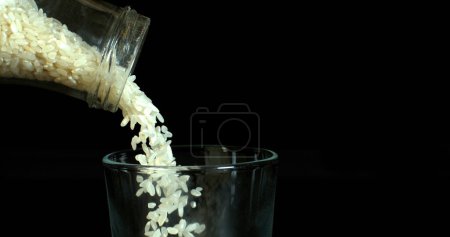 Photo for Rice falling against Black Background - Royalty Free Image