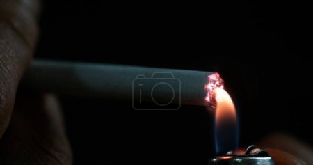Photo for Man smoking a Cigarette against Black Background - Royalty Free Image