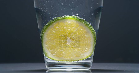 Foto de Rebanada de limón verde, citrus aurantifolia, en un vaso - Imagen libre de derechos