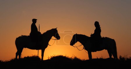 Photo for Man and Woman on a Camargue or Camarguais Horse in the Dunes at Sunrise, Manadier in the Camargue in the South East of France, Les Saintes Maries de la Mer - Royalty Free Image
