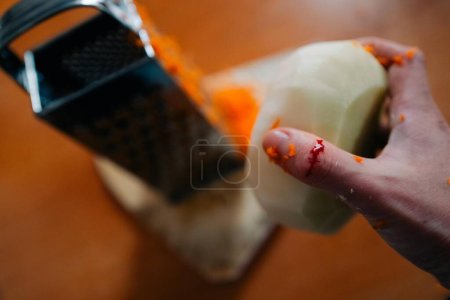 Foto de Woman cuts her finger while preparing salad for dinner. High quality photo - Imagen libre de derechos