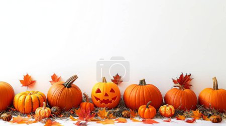 A row of carved and uncarved pumpkins is displayed on a bed of hay, accented by colorful autumn leaves. This festive setup captures the spirit of Halloween and fall.