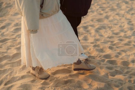 Couple walking on the beach at sunset in casual wear