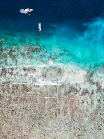 Téléchargez les photos : Belle costaline avec différentes nuances de couleur de l'océan à l'île Gili à Lombok, Indonésie. Vue aérienne verticale du bord de mer - en image libre de droit