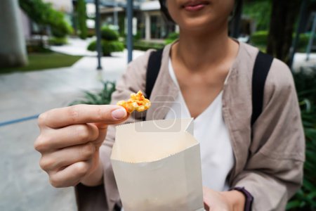 Photo for Woman holding popcorn cheese in a paper bag  in the hand - Royalty Free Image