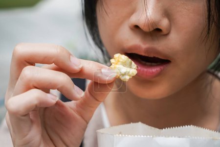 Photo for Asian woman easting popcorn full hand closed up shot. - Royalty Free Image