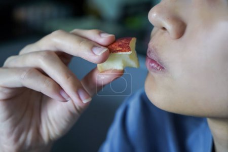 Photo for Asian woman is biting on Apple, closed up shot on her mouth eating. - Royalty Free Image