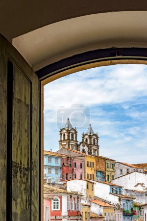 Téléchargez les photos : Vue du célèbre quartier Pelourinho dans la ville de Salvador à travers une vieille fenêtre en bois de style colonial - en image libre de droit