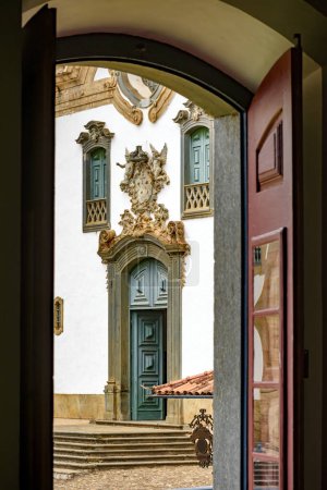 Foto de Iglesia barroca vista a través de la ventana de una antigua casa de estilo colonial en la ciudad de Mariana en Minas Gerais - Imagen libre de derechos