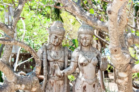 In a bright forest with verdant trees, serene ambiance is created by ancient stone statues, evoking peace