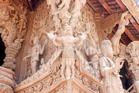 Intricate wooden carvings on ancient temple walls depicting mythological stories and divine figures