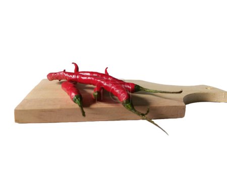 Curly red chilies on a wooden slicing board