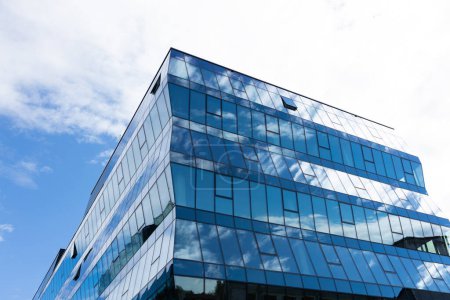 Foto de Moderno edificio de oficinas con fachada de cristal sobre un fondo de cielo. Pared de cristal transparente del edificio de oficinas. - Imagen libre de derechos