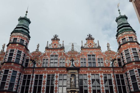 Téléchargez les photos : Vue du grand manège militaire de Gdansk. Le bâtiment est richement décoré. Il y a beaucoup de tours à pointes. - en image libre de droit