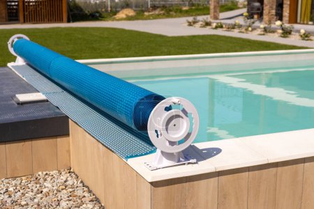 Cubierta de la piscina para la protección contra la suciedad, hojas, calefacción y agua de refrigeración, espacio de copia. Cubierta de la piscina de lona azul.