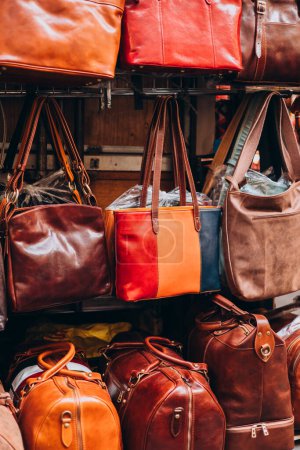 Gros plan de différents sacs en cuir sur le marché. Sacs colorés modernes à vendre. Accessoires pour femmes