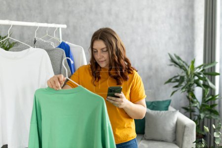 Femme sélectionnant des vêtements pour faire un don à un magasin de charité. Réutilisation, concept d'occasion. Consommateur conscient, mode de vie durable.
