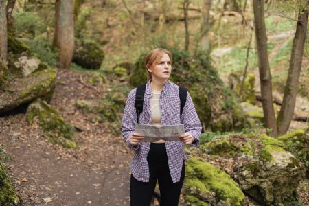 Gestresste Frau mit Landkarte Lost in the Woods, Losing the Tracks. Verwirrter Wanderer fühlt sich frustriert und allein in Not