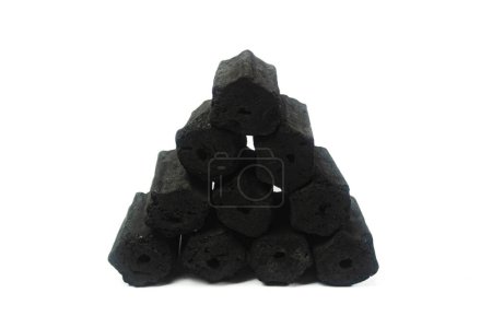 pile of hexagonal charcoal briquettes isolated on a white background