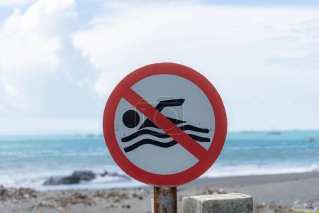 Panneau, pas de baignade sur la plage avec une plage floue comme fond