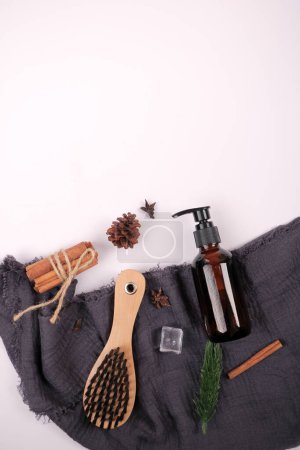 Umweltfreundliche Hautpflegeflasche mit Holzpinsel und botanischen Elementen auf weißem Hintergrund
