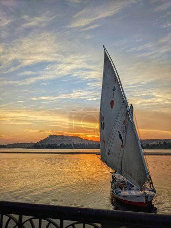 Photo for A traditional Felucca drifting peacefully on the Nile River near Aswan during a beautiful sunrise. - Royalty Free Image