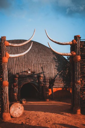 This stunning photograph captures a tribal hut with dramatic African architecture in South Africa, featuring intricate details and vibrant colors. Ideal for cultural and travel enthusiasts.