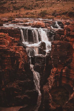A captivating scene of Burks Luck Potholes and a nearby waterfall in South Africa showcases the dramatic interplay of water and rock, creating a stunning natural oasis ideal for stock footage.