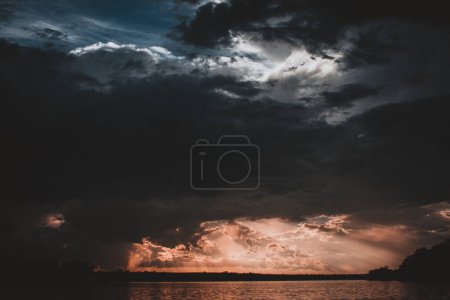 A breathtaking capture of an epic sunset storm over the Zambezi River showcasing dramatic cloud formations and intense sun rays breaking through creating a powerful and evocative scene.
