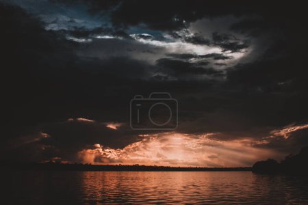 A stunning image capturing the dramatic sunset over the Zambezi River with intense clouds and radiant sun rays breaking through creating a powerful and evocative scene perfect for atmospheric projects.