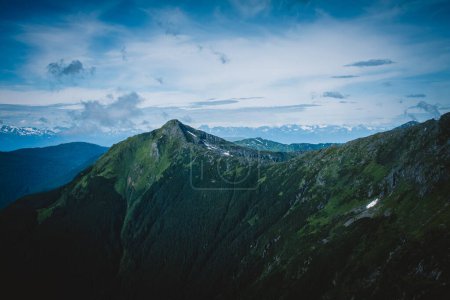 Erleben Sie die atemberaubende Schönheit der Wildnis Alaskas aus dem Hubschrauber. Diese Luftaufnahme fängt die unberührten, majestätischen Berge ein, perfekt für Natur- und Abenteuerliebhaber.
