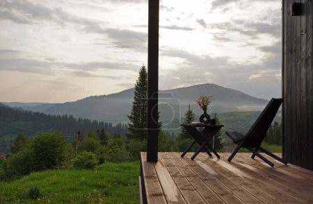 Gartenmöbel aus Holz auf der Terrasse mit Bergblick in der Ukraine