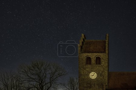 Photo for Church clocktower at night and stars in the sky, Oppe Sundby church Frederikssund, Denmark, February 9, 2024 - Royalty Free Image