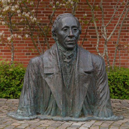 Estatua de bronce de H C Andersen en una calle adoquinada, Odense, Dinamarca, 19 de abril, 2024