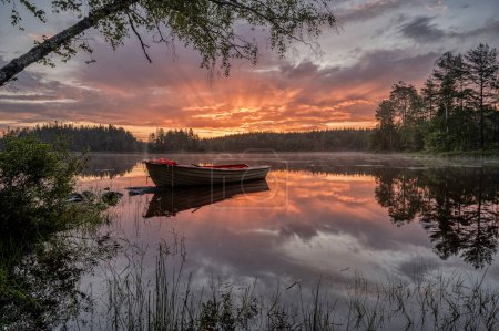 rowboat in a scandinavian lake reflecting in the water at surise, Sweden, June 15, 2024
