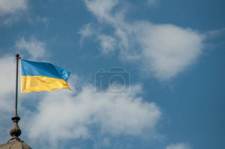 Foto de La bandera de Ucrania ondea en el techo de un antiguo edificio. - Imagen libre de derechos