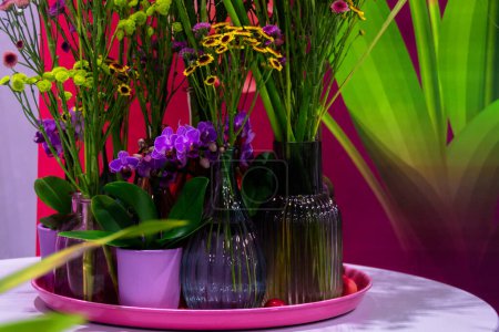 Téléchargez les photos : Bouquets de fleurs sauvages en bouteilles de verre décoratives multicolores - en image libre de droit